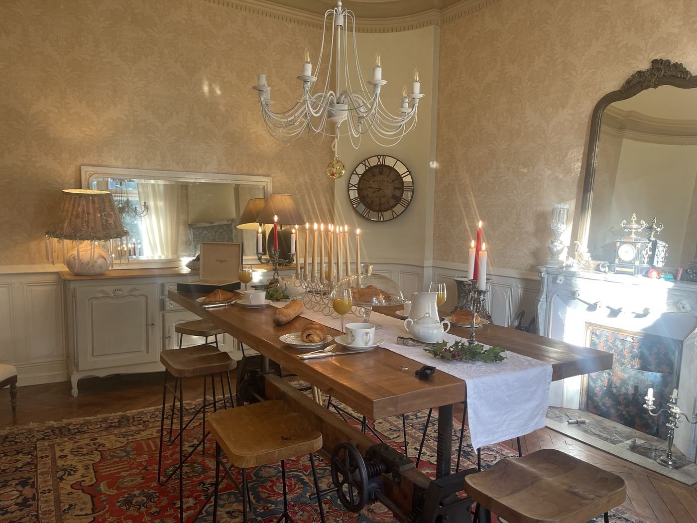 Salle du petit-déjeuner avec lustre, bougies, croissants et jus d'orange